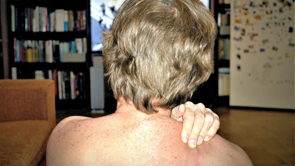 self massage man watching television and massaging himself tulemus A man watches television and massages his shoulder